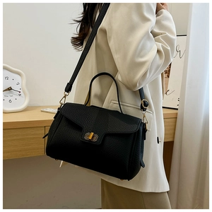 Vue détaillée du sac à main en cuir grainé noir avec fermoir rotatif doré élégant
