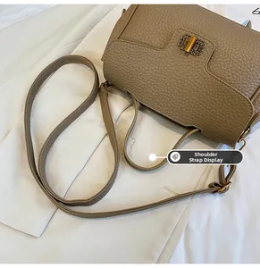 Détail du sac en cuir grainé kaki avec boucle dorée et bandoulière réglable