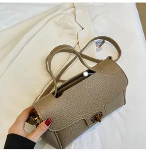Détail d'un sac à main en cuir grainé kaki avec fermoir chaîne doré et texture élégante