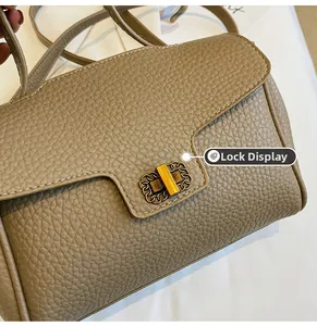 Détail du fermoir doré vintage sur sac à main en cuir beige à grain lychee