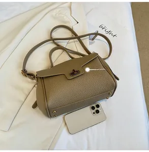 Détail du sac à main en cuir grainé avec finitions métalliques et référence de taille iPhone