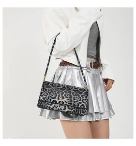 Detail of leopard print baguette bag featuring gold metal trim on the front flap