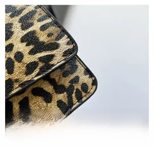 Macro shot of leopard print fabric texture and stitching on trendy baguette shoulder bag