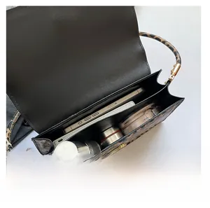 Detail showing internal capacity of the leopard print bag with makeup and phone