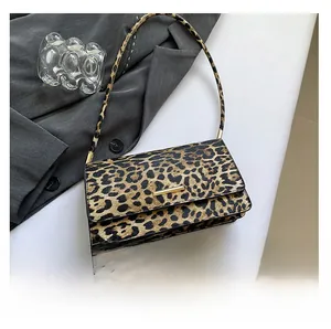 Detailed close-up of leopard print texture and gold clasp on minimalist handbag