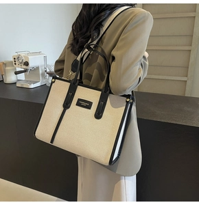 Detail of the high-quality stitching on the canvas tote bag with contrast leather handles