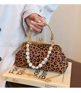 Detail of leopard print shell bag with gold handle and decorative shell chain strap