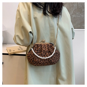 Detail showing vintage leopard print fabric shell bag with pearl handle and gold chain