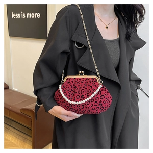 Close-up of red leopard print shell bag with pearl handle and golden chain strap