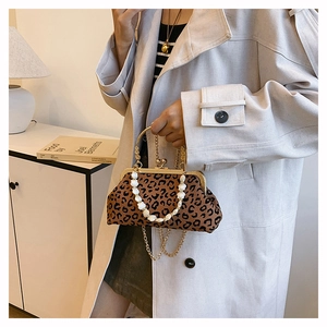 Detail of leopard print shell bag featuring white pearl handle and gold metal clasp