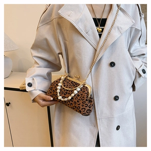 Detail of leopard print shell bag with gold clasp and decorative beaded handle strap