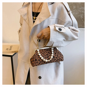 Leopard print shell bag detail with pearl beaded handle and gold chain strap worn by model