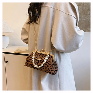 Macro detail of leopard print seashell bag with gold chain and beaded handle