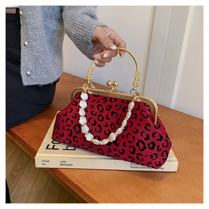 Detail of red leopard print shell bag with golden metal handle and shell chain