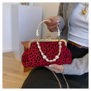 Detailed view of leopard print shell bag with gold handle and shell bead chain