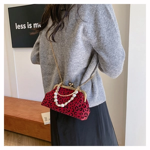 Close-up of leopard print shell bag with pearl handle and golden chain detail