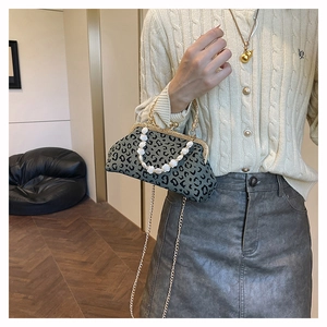 Detail of leopard print bag with shell beads handle and elegant gold metal chain