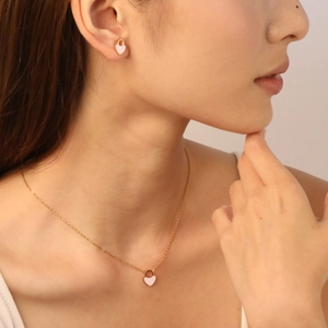 Set collana con ciondolo a cuore rosa e orecchini a lobo indossati da una modella