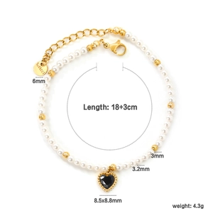 Detail of beaded heart pendant and gold metal beads on a pearl strand bracelet