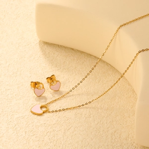 Dettaglio del ciondolo a lucchetto e orecchini a cuore in smalto rosa e oro