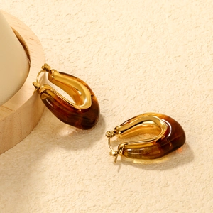 Macro view of French retro amber resin earrings with polished gold-tone metal texture