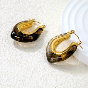 Nahaufnahme von Retro U-Ohrringen mit Goldmetall und bernsteinfarbener Harztextur