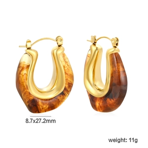 Detail shot of gold U-shaped earrings with resin texture and 8.7x27.2mm size specs