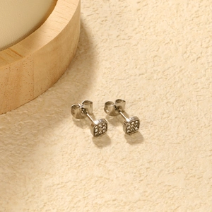 Macro shot of silver square stud earrings with pave-set crystals on stone background