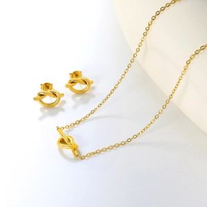 Gros plan d'un ensemble de bijoux nœud doré comprenant un collier et des boucles d'oreilles