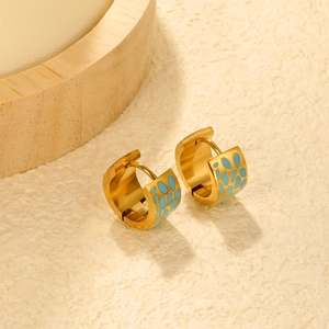 Detail of gold bamboo hoop earrings with light blue enamel drip oil finish on stone