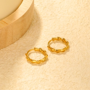 Detailed view of gold bamboo texture hoop earrings with polished metallic surface