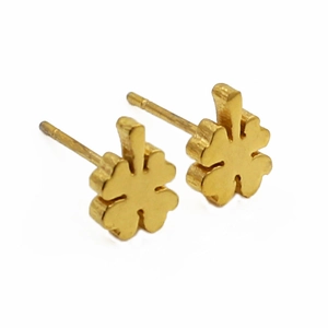 Macro detail of gold four-leaf clover stud earrings with brushed metal finish
