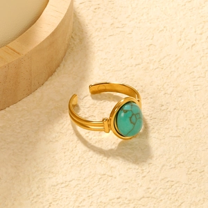 Detail view of a gold-plated open ring featuring a green turquoise oval stone setting