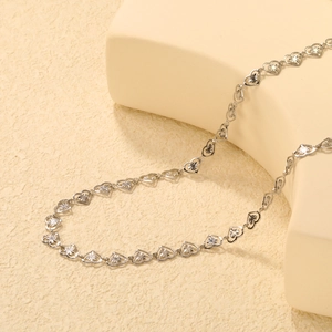 Detail of silver hollow heart chain necklace with starburst engraved pattern and texture
