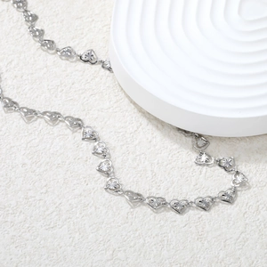 Detailed view of silver heart-shaped links with radiant sunburst texture engraving