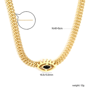 Detail of gold chain necklace featuring evil eye pendant with black stone and extension link