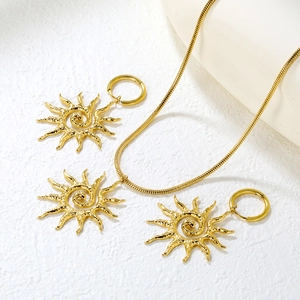 Macro d'ensemble bijoux soleil doré avec pendentif spirale et boucles d'oreilles