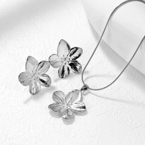 Macro detail of silver stainless steel petal jewelry set with radial brushed texture