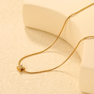 Vue détaillée d'un collier chaîne serpent dorée avec pendentif en X étincelant
