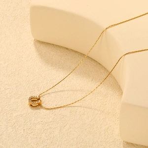Collier élégant en or avec pendentif en U serti de zircons sur un socle beige chic