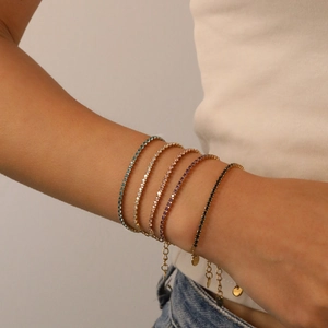 Detaillierte Nahaufnahme von bunten Zirkon-Tennisarmbändern am Handgelenk einer Frau