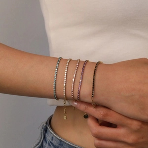 Detail von fünf bunten Zirkonia-Tennisarmbändern mit Goldbeschichtung und Verstellkette