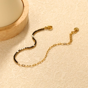 Detailansicht der goldener Büroklammerkette und schwarzem Zirkon-Tennisarmband mit Verschluss