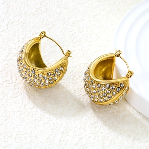Close-up of gold chunky C-shaped earrings with pave-set sparkling white rhinestones