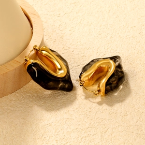 Detail of vintage resin earrings with gold metal accents and marble texture design