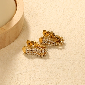 Detail of gold U-shaped earrings with three rows of pavé-set white zircons