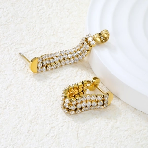 Detail of C-shaped gold-plated stainless steel earrings with triple rows of white zircons