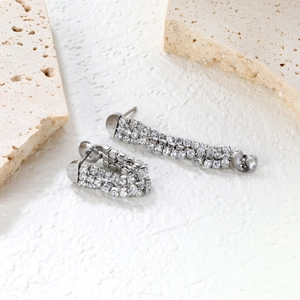 Detailed macro view of triple-row sparkling zircon tassel earrings in silver finish