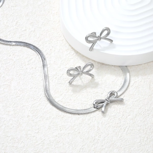 Polished stainless steel jewelry set featuring bow-knot pendant necklace and matching stud earrings