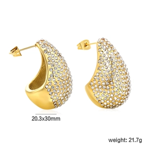 Macro detail of teardrop C-shape earrings with gold finish and white rhinestones